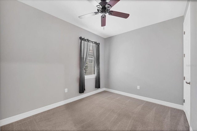 carpeted spare room with baseboards and a ceiling fan