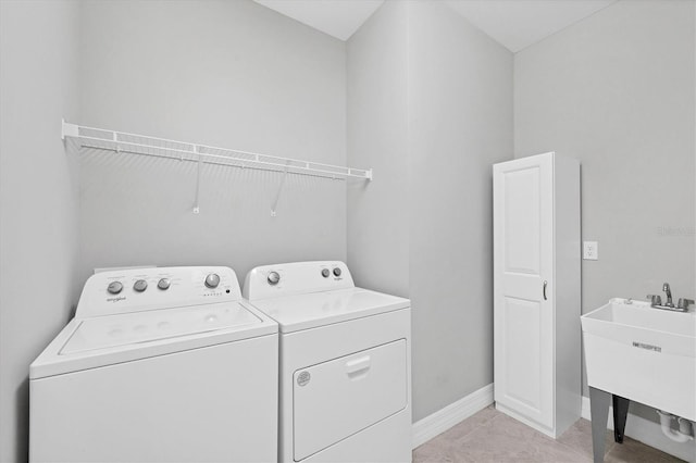 laundry room featuring washer and clothes dryer, a sink, light tile patterned floors, baseboards, and laundry area