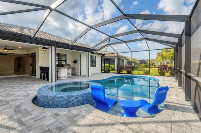 view of pool featuring a pool with connected hot tub, ceiling fan, area for grilling, an outdoor kitchen, and a patio