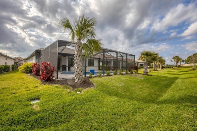 rear view of house featuring a yard, a swimming pool, a lanai, and a patio area