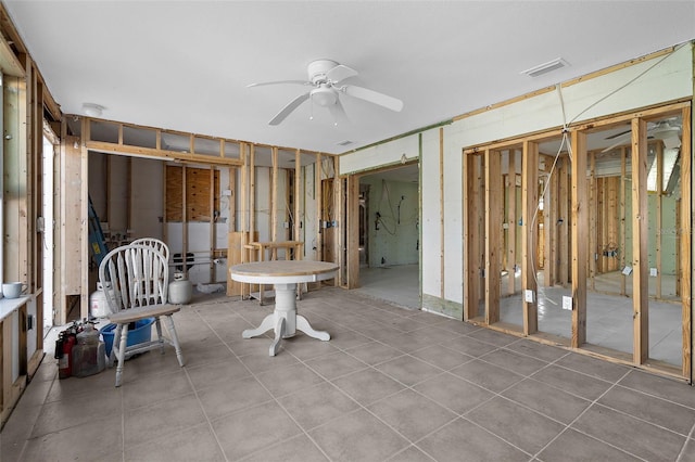 interior space with tile patterned floors, visible vents, and ceiling fan