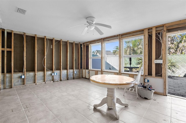 unfurnished sunroom with a wealth of natural light, visible vents, and a ceiling fan