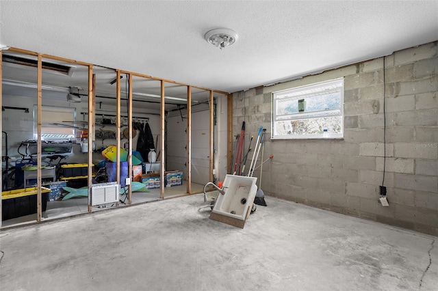 basement with a textured ceiling and concrete block wall