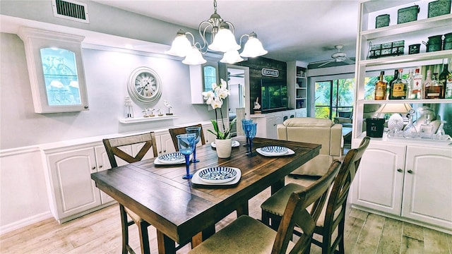 dining area featuring a notable chandelier, visible vents, and light wood-type flooring