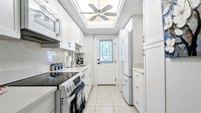 kitchen with ceiling fan, light countertops, white cabinets, white appliances, and a raised ceiling