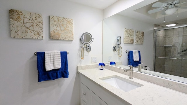 bathroom featuring a ceiling fan, vanity, and a shower stall