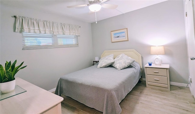 bedroom with light wood finished floors, ceiling fan, and baseboards