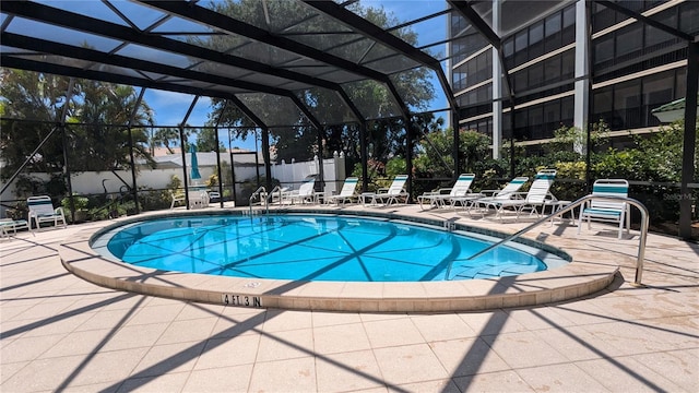 pool with glass enclosure, a patio, and fence