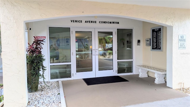 view of exterior entry with stucco siding and french doors