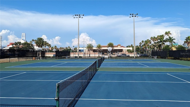 view of tennis court with community basketball court and fence