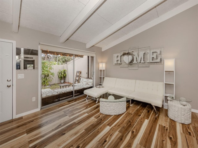 living room with lofted ceiling with beams, baseboards, and wood finished floors