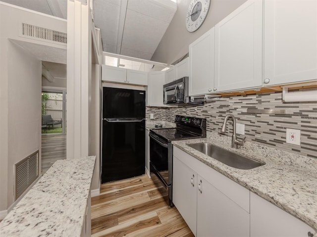 kitchen with visible vents, a sink, black appliances, white cabinetry, and backsplash