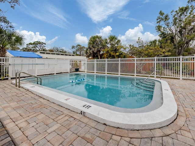 community pool featuring a patio area and a fenced backyard