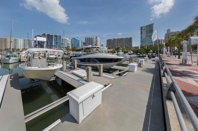 view of dock featuring a water view, boat lift, and a city view