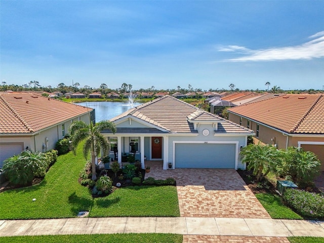 view of front of property with a tiled roof, a front yard, decorative driveway, and a garage