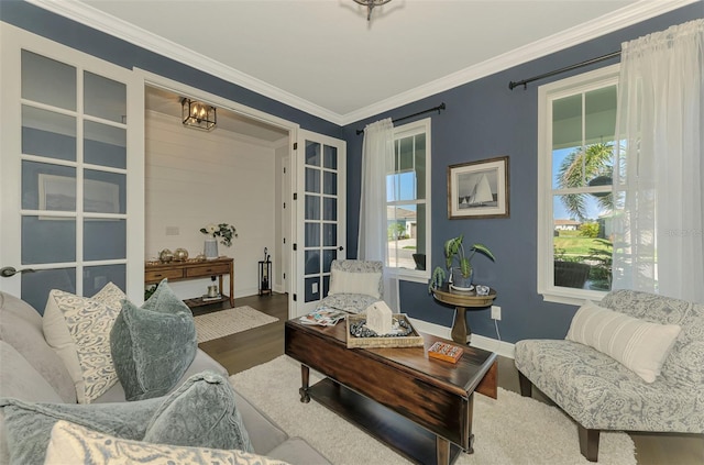 living area featuring baseboards, wood finished floors, and crown molding