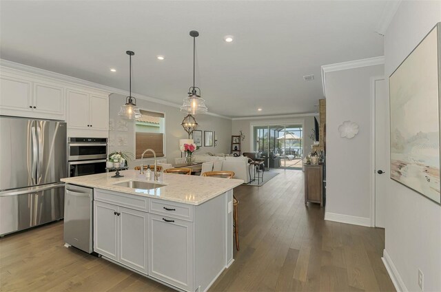 kitchen featuring white cabinetry, ornamental molding, a sink, and stainless steel appliances