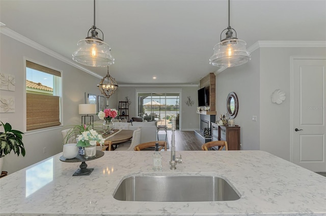 kitchen featuring open floor plan, hanging light fixtures, and ornamental molding