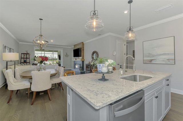 kitchen featuring open floor plan, ornamental molding, stainless steel dishwasher, a sink, and wood finished floors