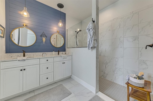 full bath featuring a sink, walk in shower, marble finish floor, baseboards, and double vanity