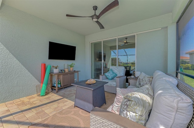 view of patio / terrace with a ceiling fan and an outdoor living space with a fire pit
