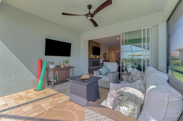 living room featuring ceiling fan and a textured wall