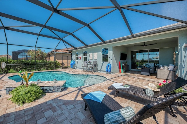 outdoor pool featuring a ceiling fan, glass enclosure, and a patio area