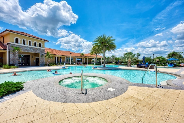 pool featuring a hot tub and a patio