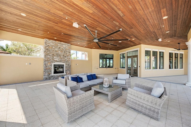 view of patio featuring ceiling fan and an outdoor living space with a fireplace