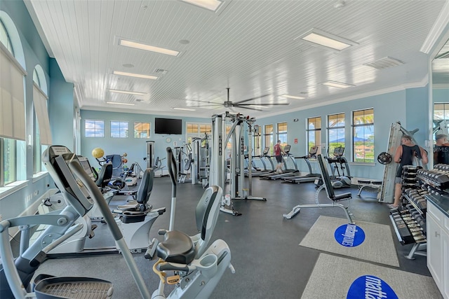 gym with a ceiling fan, ornamental molding, and visible vents
