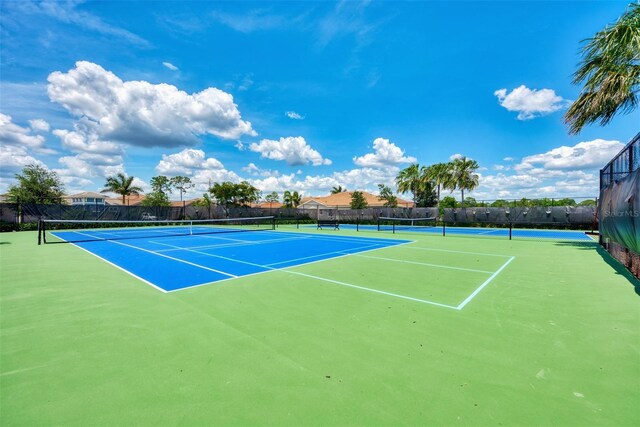 view of tennis court featuring fence and community basketball court