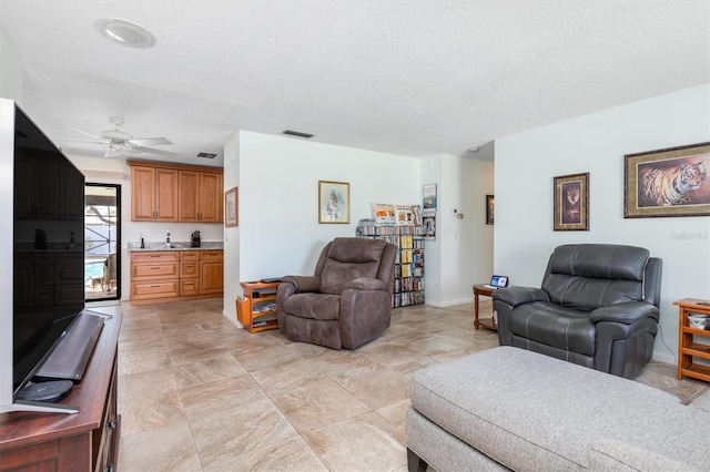 2102 Alaric St, Port Charlotte, FL 33952 - living area featuring ceiling fan, a textured ceiling, and baseboards