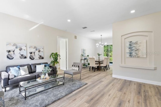 living room with baseboards, a notable chandelier, wood finished floors, and recessed lighting