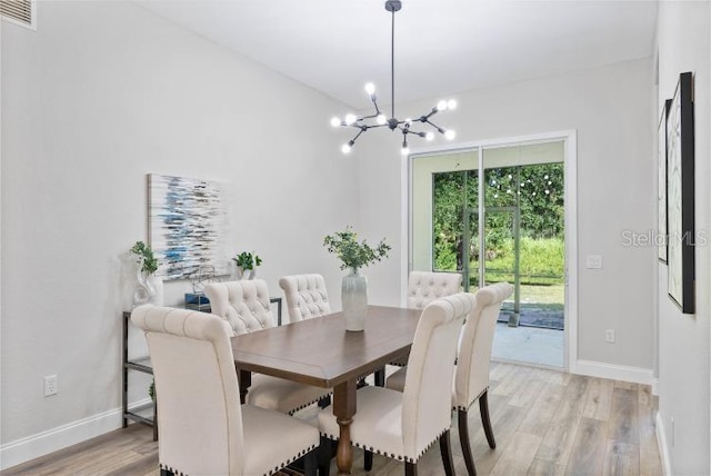 dining room with baseboards, visible vents, light wood-type flooring, and a notable chandelier