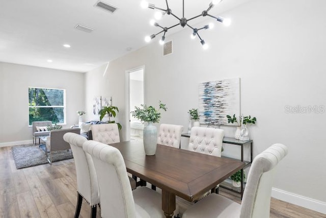dining room with an inviting chandelier, baseboards, light wood finished floors, and visible vents