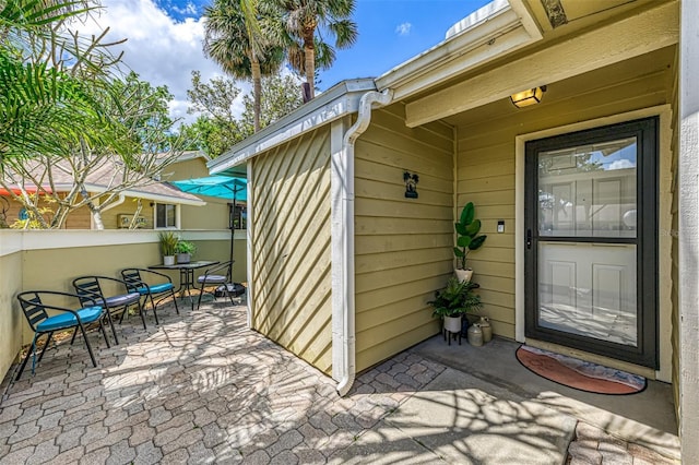 property entrance featuring outdoor dining space and a patio