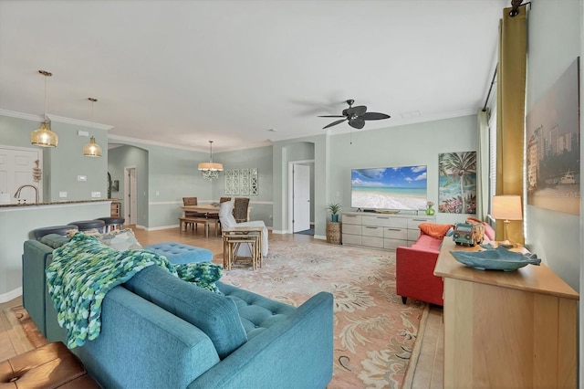 9312 Coachman Dr, Venice, FL 34293 - living area with ornamental molding, arched walkways, light wood-style floors, baseboards, and ceiling fan