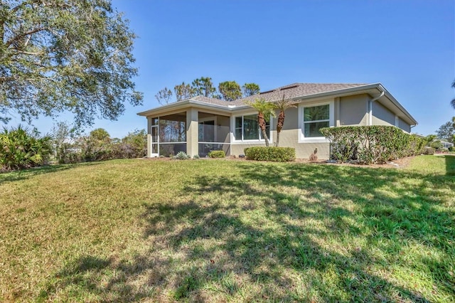 9312 Coachman Dr, Venice, FL 34293 - back of house featuring a yard, a sunroom, and stucco siding