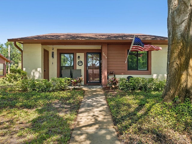 entrance to property with a shingled roof