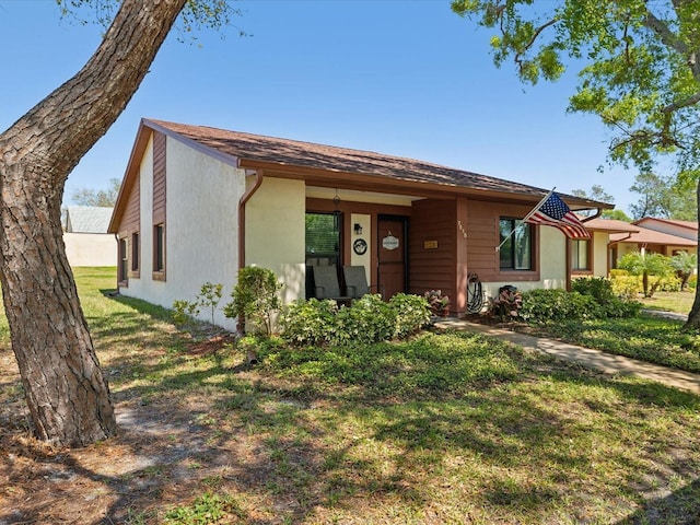 view of front of home with stucco siding and a front lawn