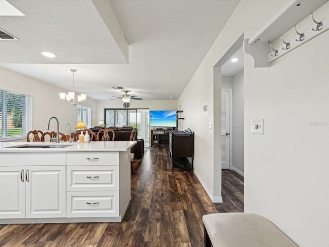 kitchen featuring white cabinets, a sink, a healthy amount of sunlight, and dark wood finished floors