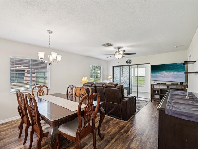 dining area with baseboards, dark wood-style floors, visible vents, and ceiling fan with notable chandelier
