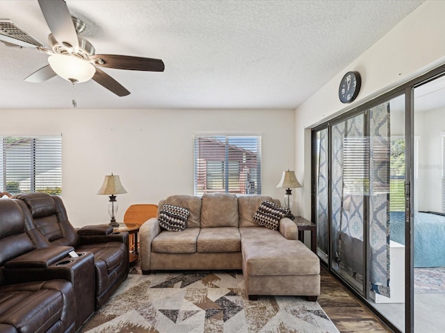 living room featuring a ceiling fan, wood finished floors, and a textured ceiling