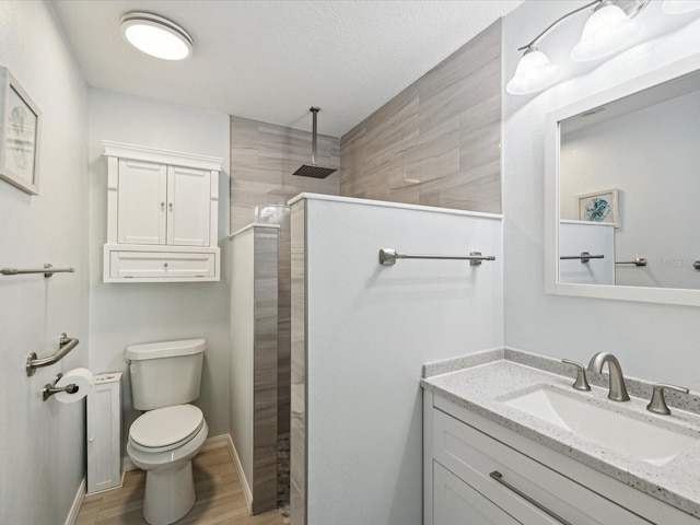 bathroom with toilet, vanity, wood finished floors, and walk in shower