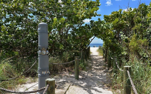 surrounding community featuring a view of the beach and a water view