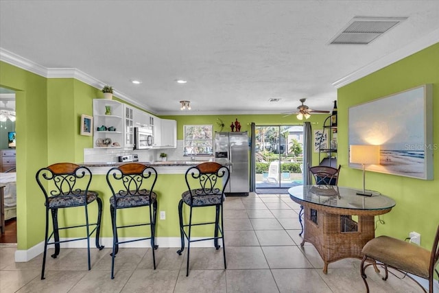 kitchen with stainless steel appliances, open shelves, visible vents, a ceiling fan, and a peninsula
