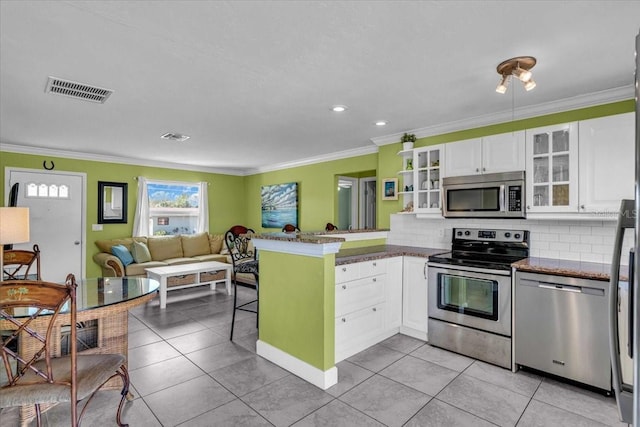 kitchen featuring white cabinets, stainless steel appliances, visible vents, a peninsula, and glass insert cabinets