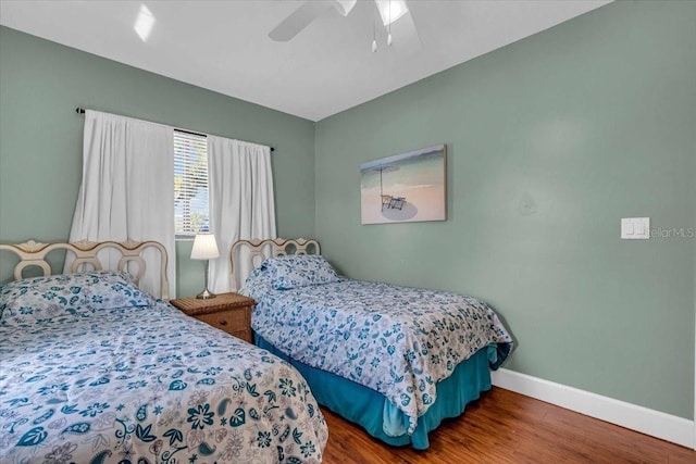 bedroom featuring wood finished floors, baseboards, and a ceiling fan