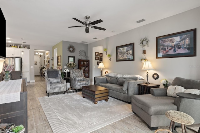 11655 Renaissance Blvd, Venice, FL 34293 - living room featuring visible vents, ceiling fan with notable chandelier, and wood tiled floor