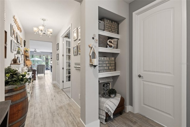 11655 Renaissance Blvd, Venice, FL 34293 - hall with baseboards, wood finished floors, and a chandelier